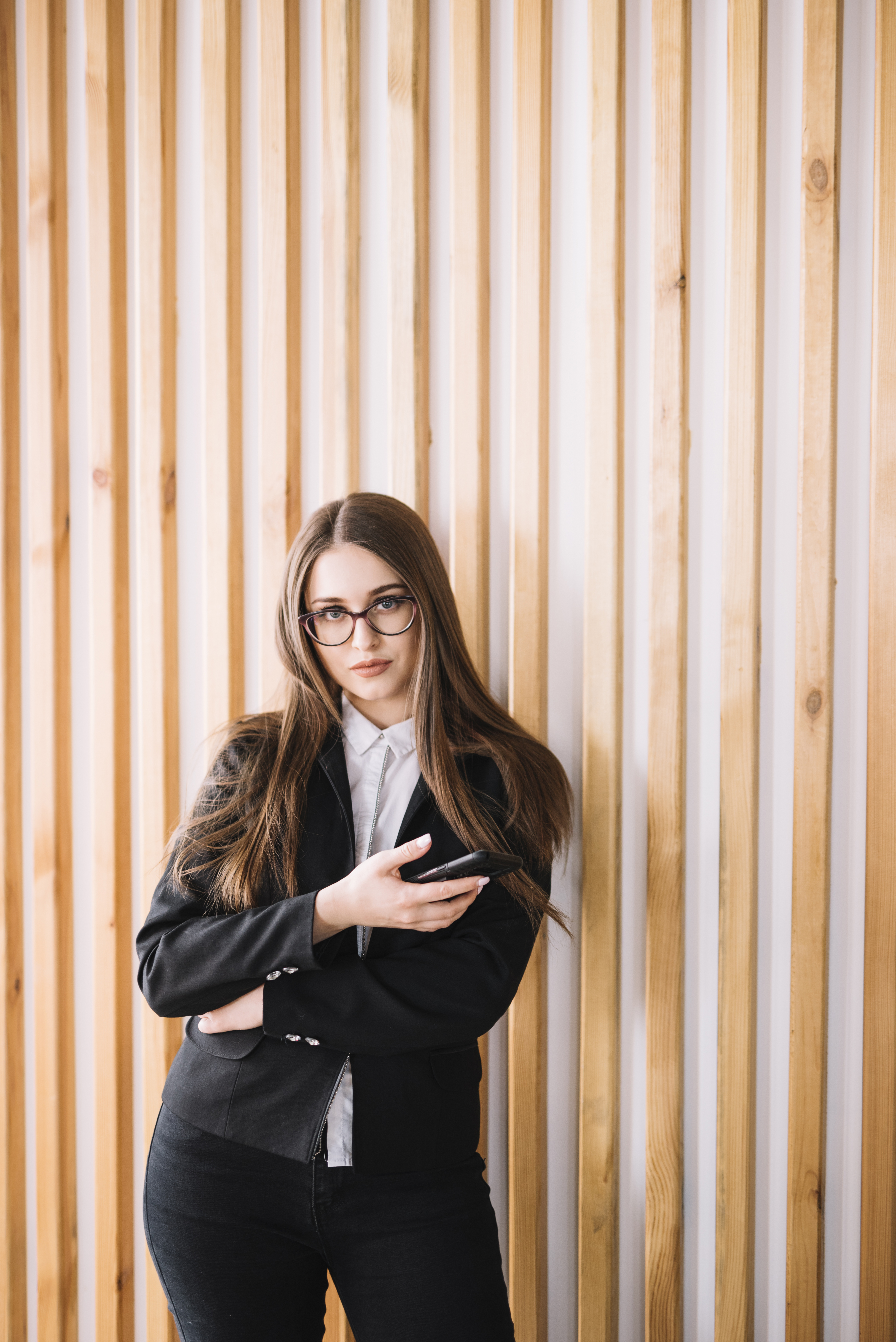 young-business-woman-using-smartphone-wooden-wall.jpg