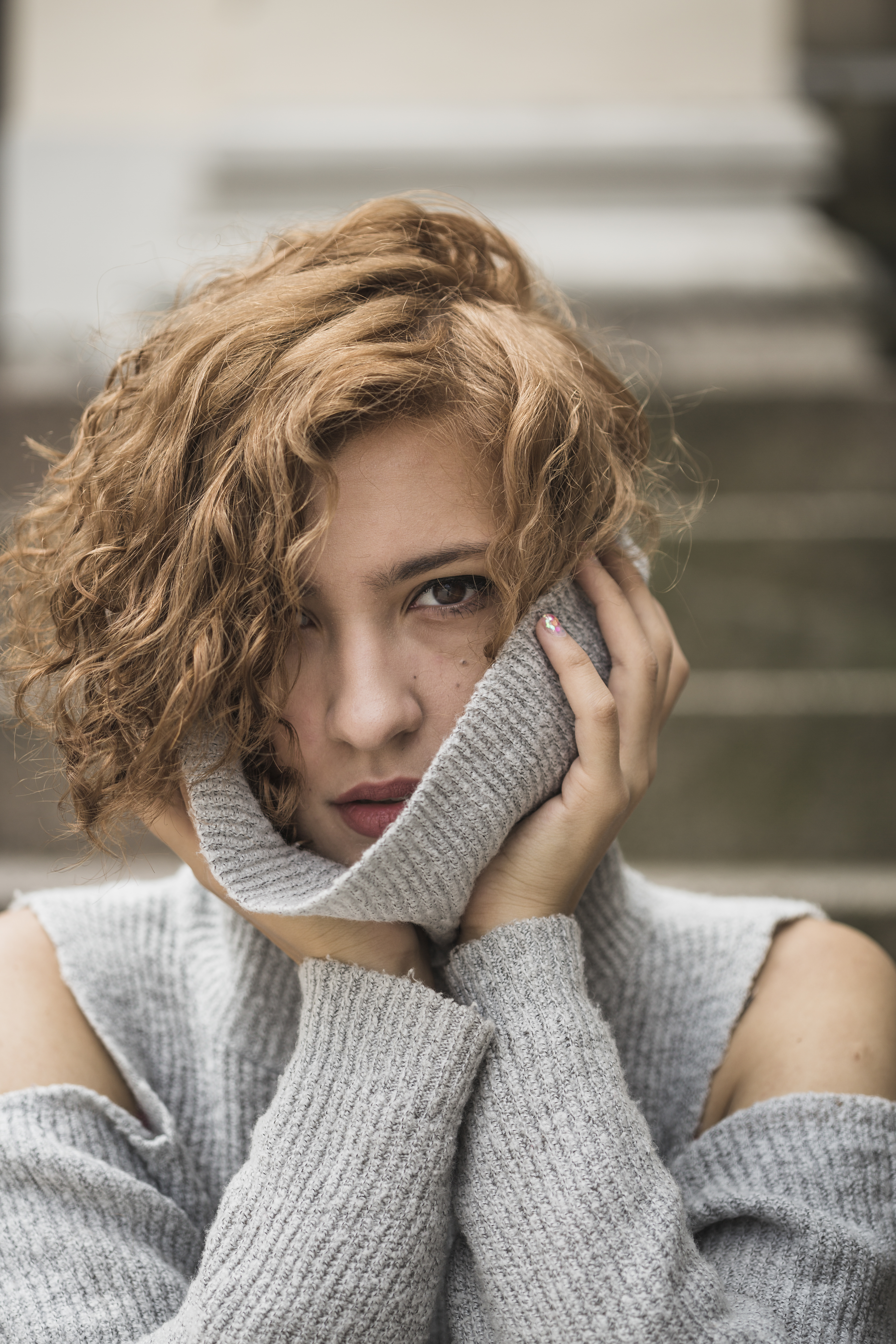 charming-lady-with-short-curly-hair-holding-sweater-s-collar.jpg