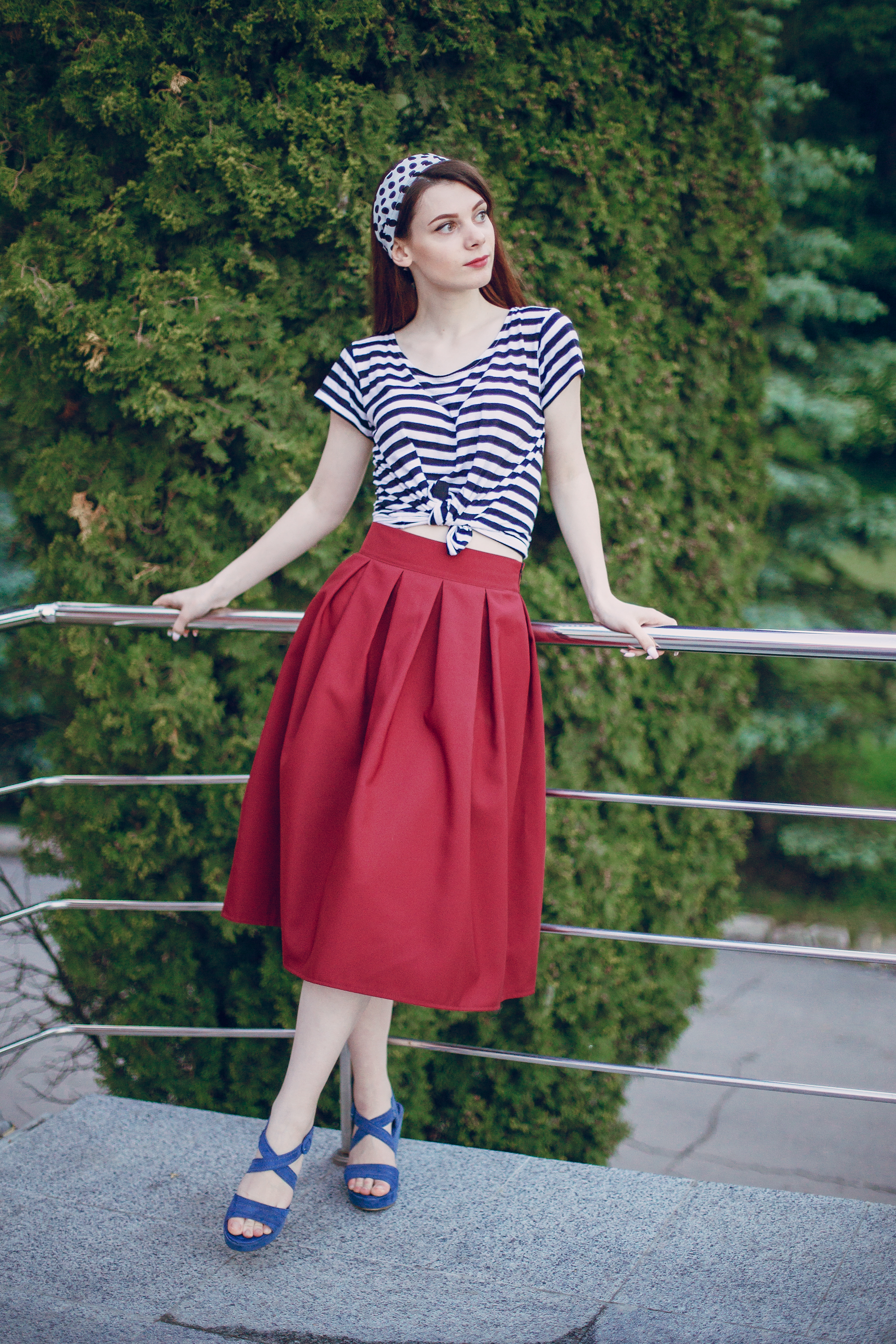 young-girl-with-red-skirt-leaning-white-metal-railing.jpg
