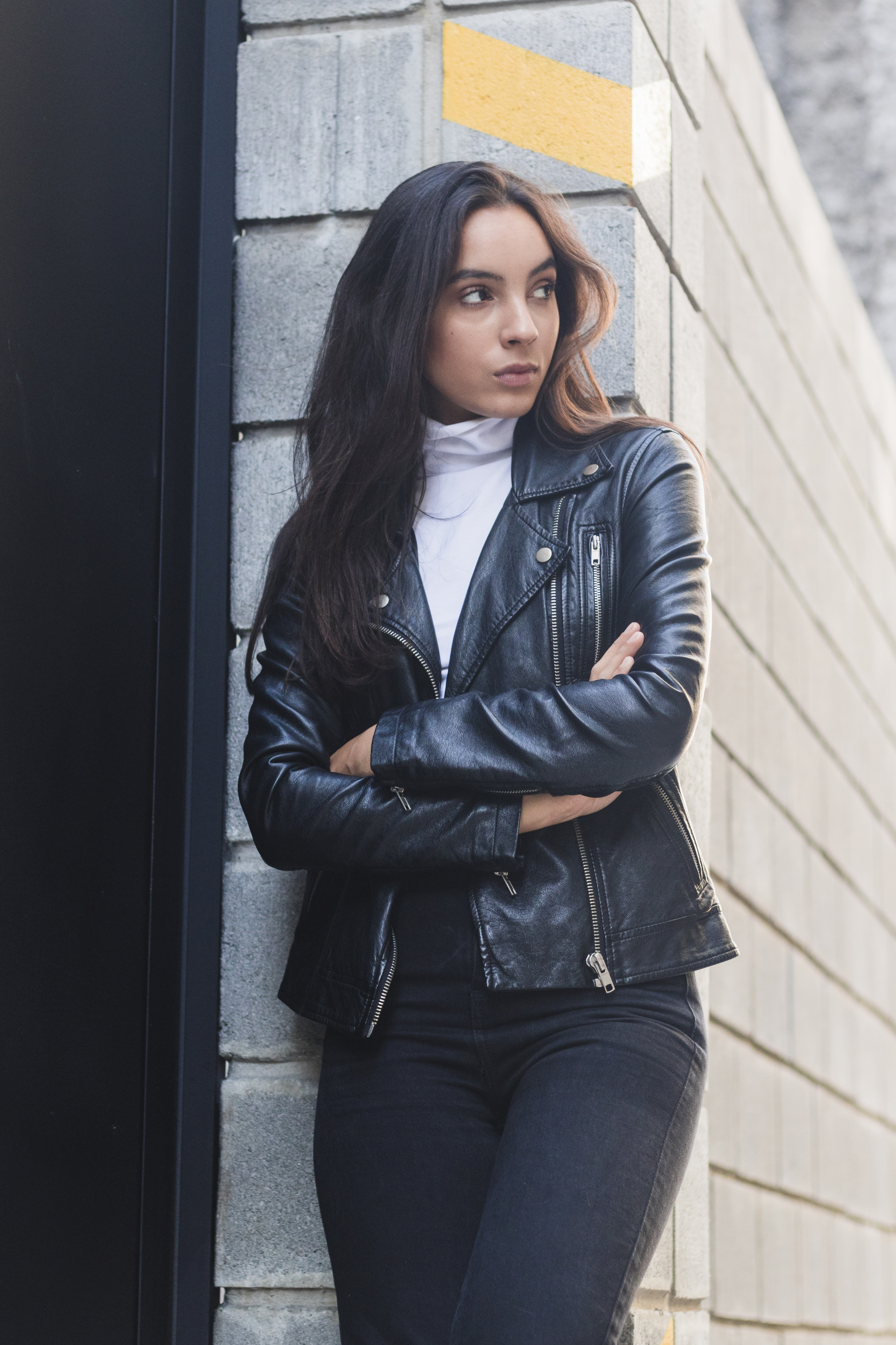 beautiful-young-woman-leather-jacket-standing-near-wall-with-her-arms-crossed.jpg